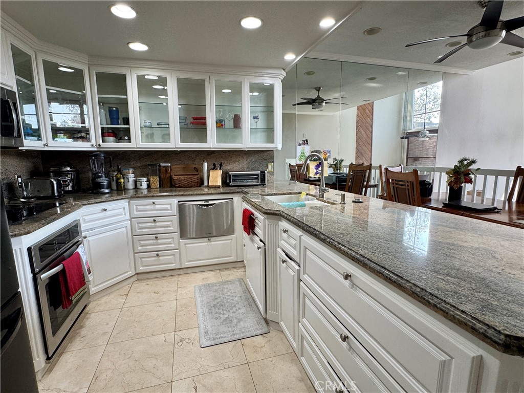 6312 Marina Pacifica Drive Long Beach, CA 90803 - Photo 5 of 30 a kitchen with stainless steel appliances kitchen island granite countertop a sink and cabinets
