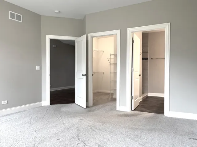 an empty room with windows and a closet