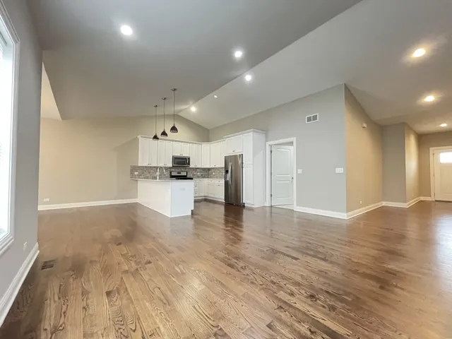 a view of a kitchen with a sink and dishwasher a refrigerator with wooden floor