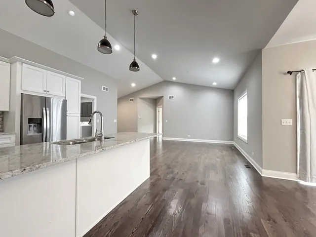 a large kitchen with sink and refrigerator