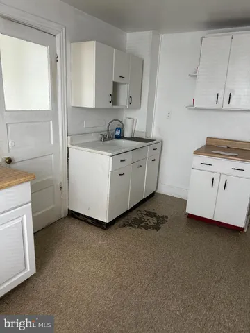 a kitchen with granite countertop white cabinets and white appliances