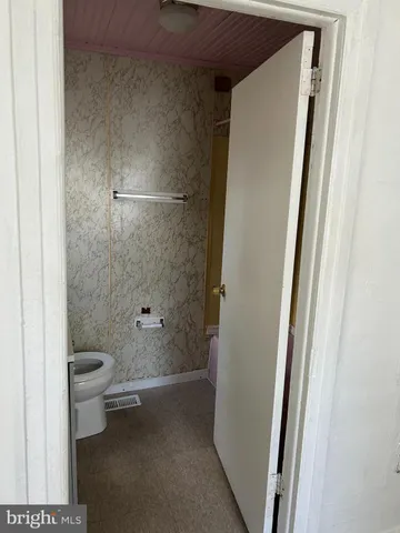a bathroom with a granite countertop toilet and a shower