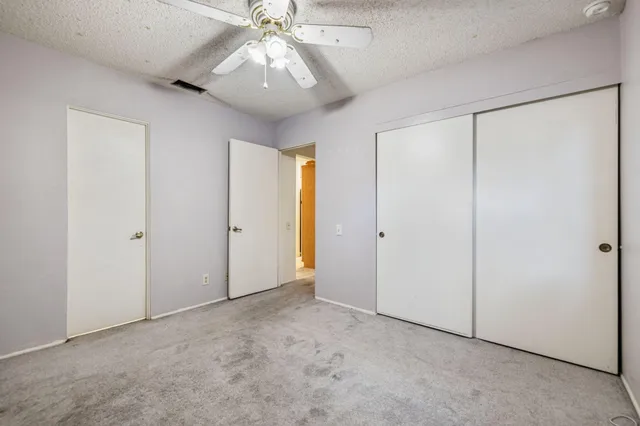 an empty room with a ceiling fan and a shower