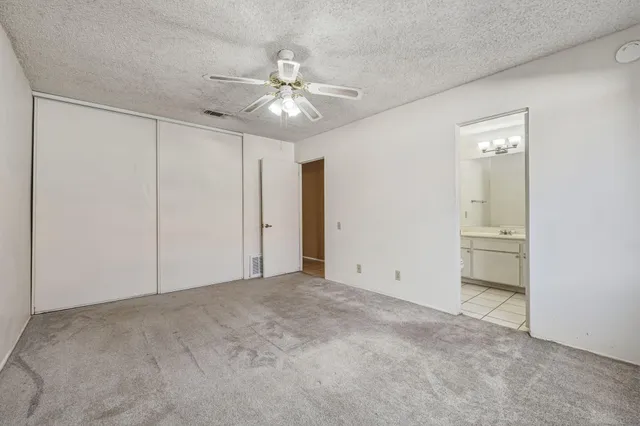 an empty room with a ceiling fan and a bathroom