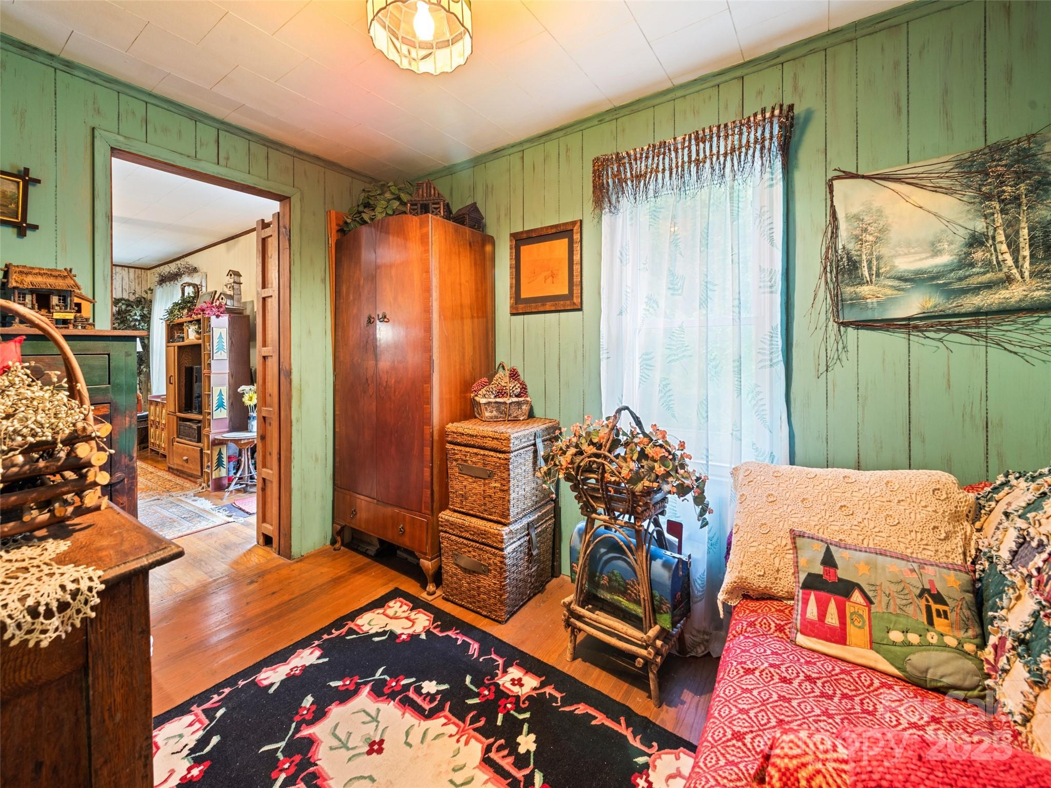 4828 Max Patch Road Clyde, NC 28721 - Photo 35 of 41 a bedroom with a bed and a chandelier