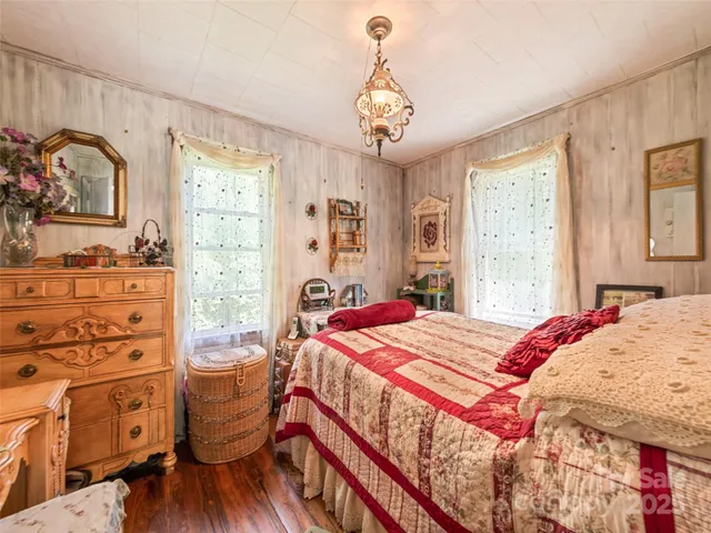 a bedroom with a bed and dresser with mirror