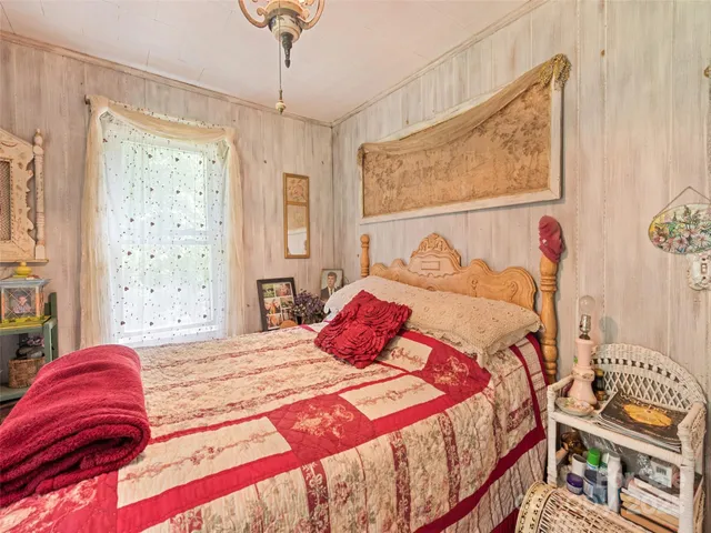 a bedroom with a bed and a painting on the wall