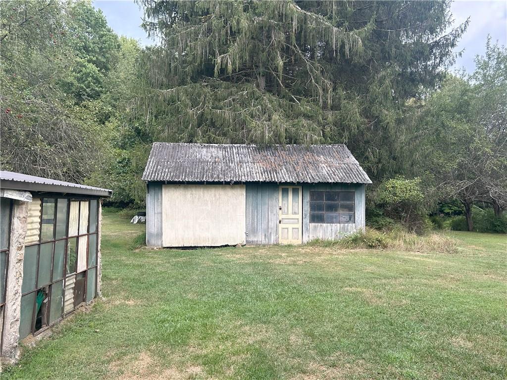 53 Hurd Road Rochester Mills, PA 15771 - Photo 34 of 35 a backyard of a house with large trees and a barn with large trees