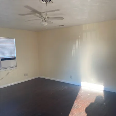 an empty room with a ceiling fan and a window