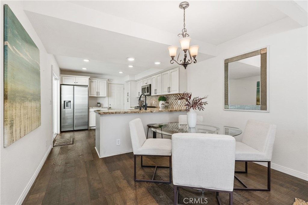 1041 Tustin Pines Way Tustin, CA 92780 - Photo 11 of 32 a view of a dining room with furniture a chandelier and wooden floor