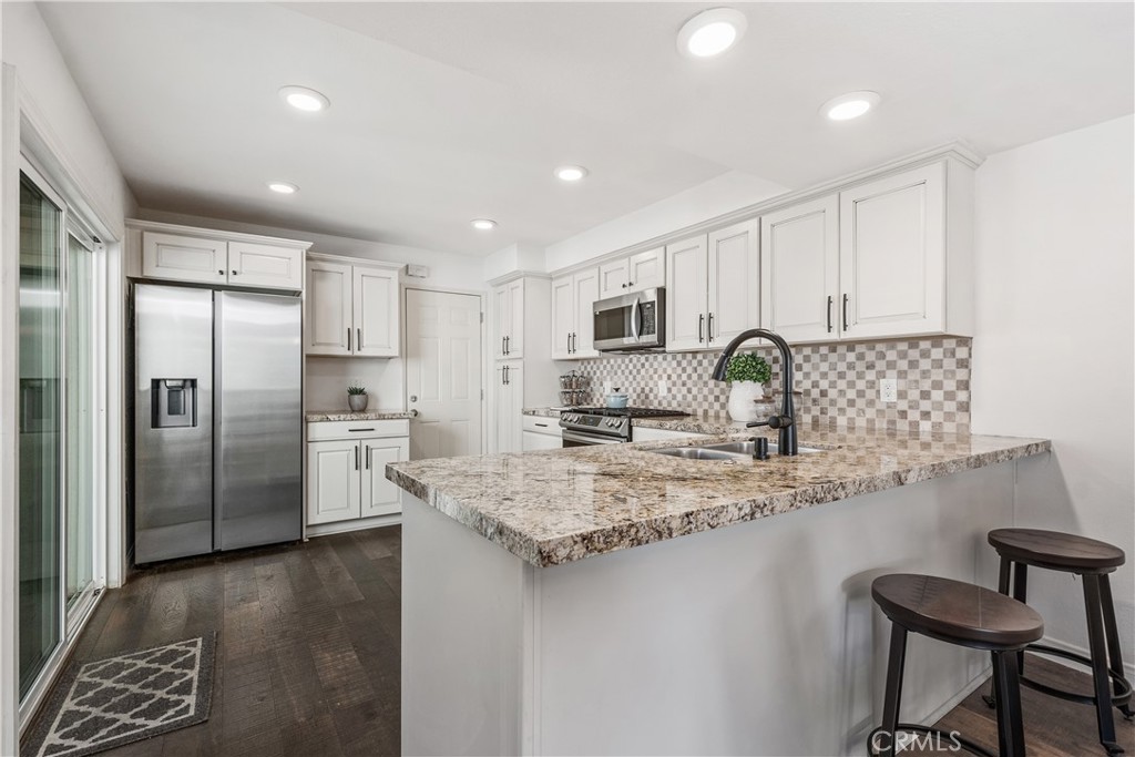 1041 Tustin Pines Way Tustin, CA 92780 - Photo 15 of 32 a kitchen with stainless steel appliances granite countertop a sink refrigerator and cabinets