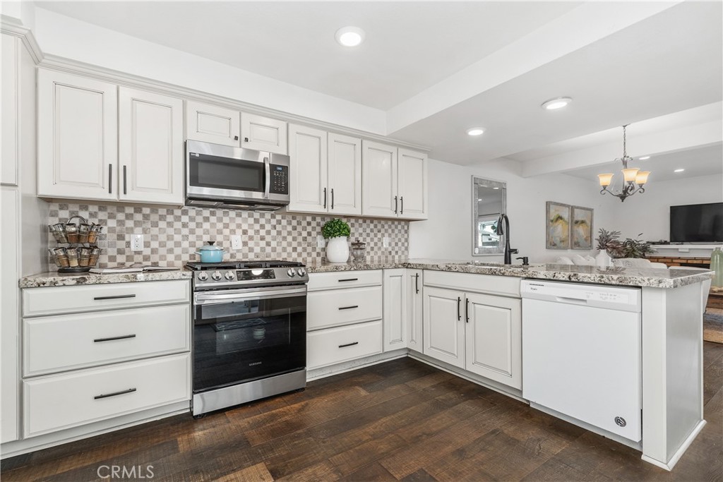 1041 Tustin Pines Way Tustin, CA 92780 - Photo 18 of 32 a kitchen with granite countertop white cabinets and stainless steel appliances