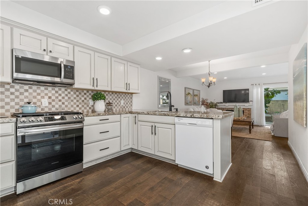 1041 Tustin Pines Way Tustin, CA 92780 - Photo 19 of 32 a kitchen with granite countertop white cabinets stainless steel appliances and sink
