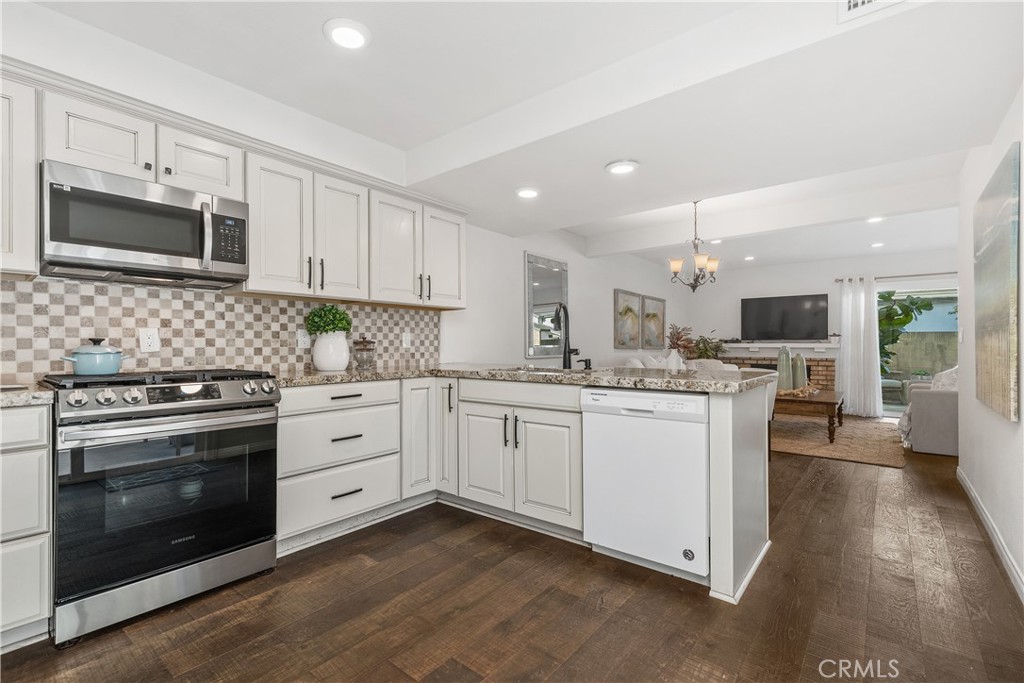 1041 Tustin Pines Way Tustin, CA 92780 - Photo 19 of 32 a kitchen with granite countertop white cabinets stainless steel appliances and sink