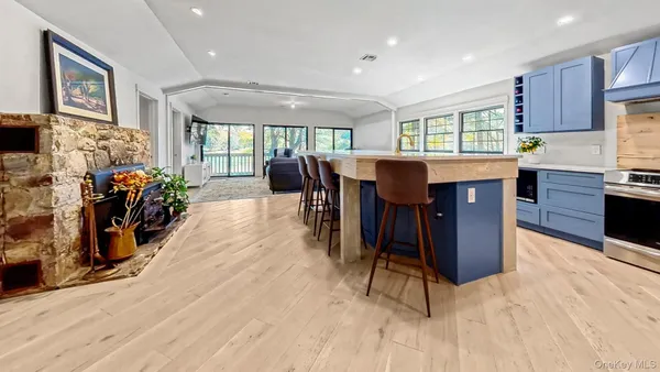 a large kitchen with stainless steel appliances kitchen island wooden cabinets a sink and a large window