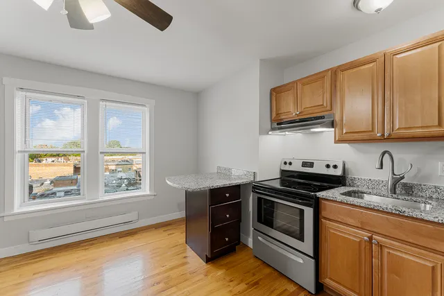 a kitchen with stainless steel appliances granite countertop a stove a sink and a microwave