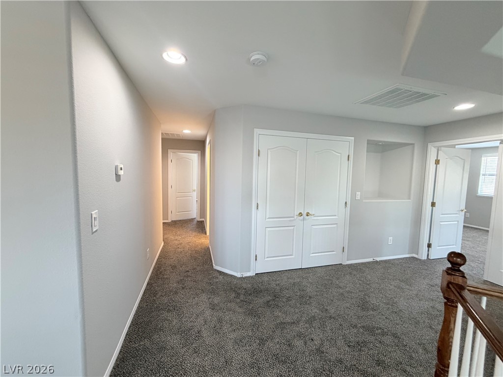 6116 Rabbit Track Street Las Vegas, NV 89130 - Photo 8 of 28 A well-lit landing features soft carpeting and ample closet space.
