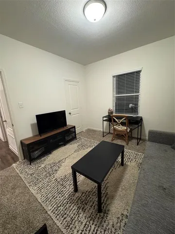 a living room with furniture a rug and a window
