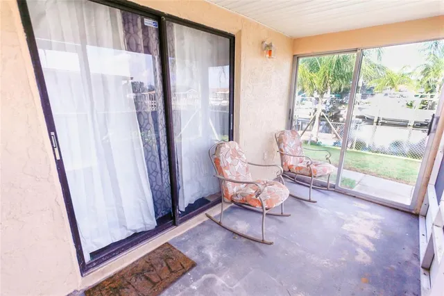 a living room with chairs and a floor to ceiling window