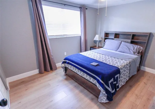 a bed sitting in a bedroom next to a window