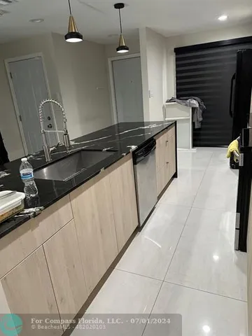 a kitchen with a sink a stove top oven and cabinets