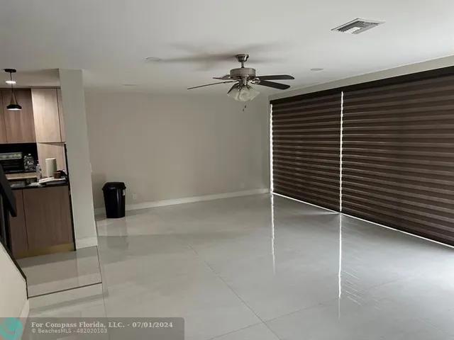 a view of a livingroom with a chair and a ceiling fan