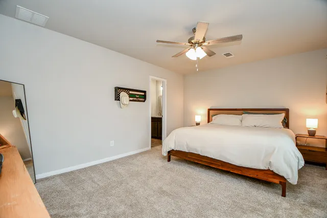 a bedroom with a bed and a ceiling fan