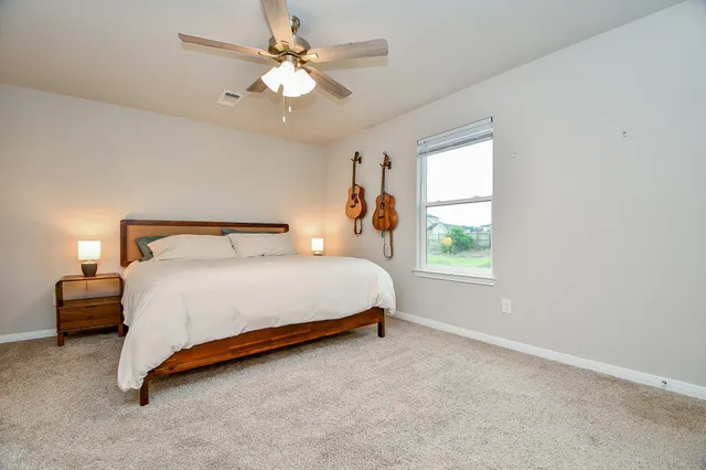 a bedroom with a bed chandelier and a window