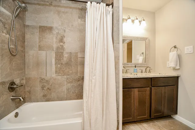 a bathroom with a tub sink and mirror