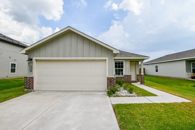 a front view of house with yard and garage