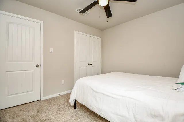a bedroom with a bed and a ceiling fan