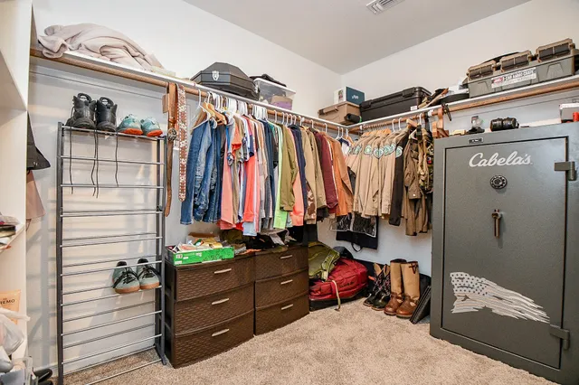 a view of walk in closet with clothes and shoes