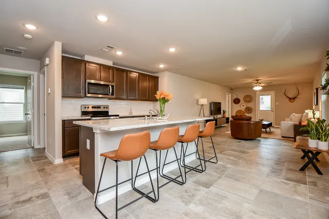 a kitchen with stainless steel appliances kitchen island granite countertop a refrigerator and cabinets