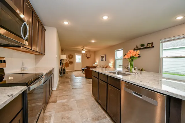 a kitchen with stainless steel appliances granite countertop a sink stove and cabinets