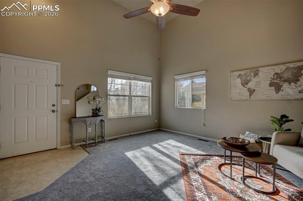 5653 Saint Patrick View Colorado Springs, CO 80923 - Photo 6 of 43 Beautiful entryway into the living room with new carpet, high ceilings, and fan.