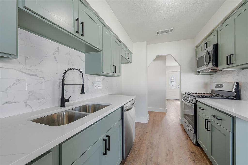 1016 Calcutta Street Hurst, TX 76053 - Photo 11 of 34 a kitchen with stainless steel appliances a sink stove and cabinets