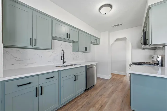 a kitchen with sink stove and cabinets