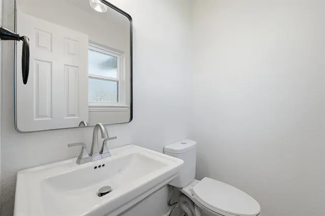 a bathroom with a sink a toilet and mirror