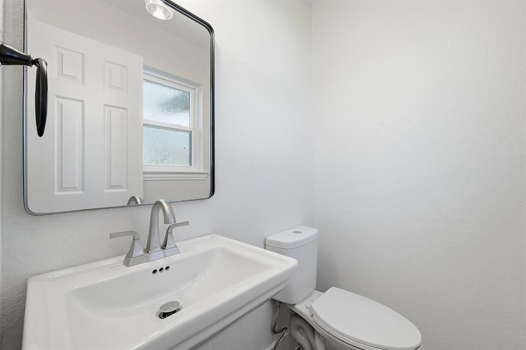 1016 Calcutta Street Hurst, TX 76053 - Photo 20 of 34 a bathroom with a sink a toilet and mirror