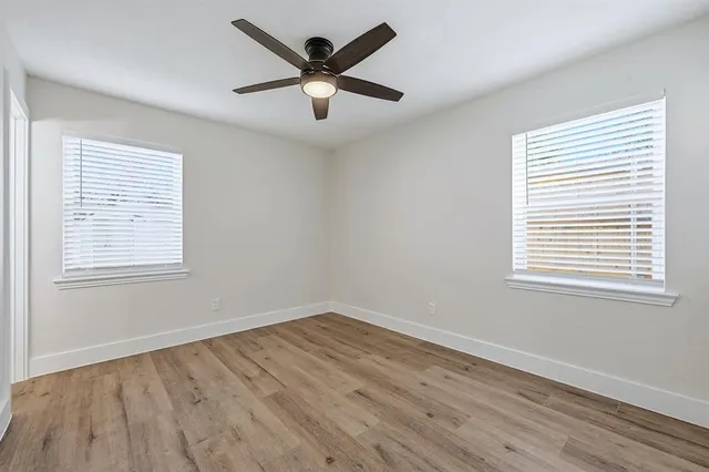 a view of a big room with wooden floor and windows