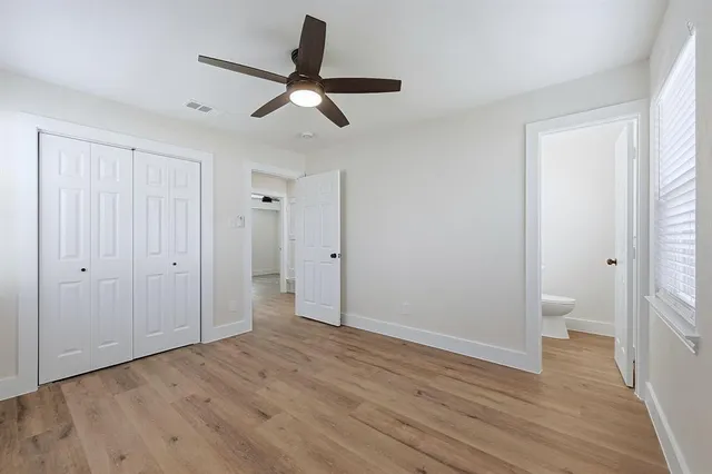 a view of a room with wooden floor and bathroom view