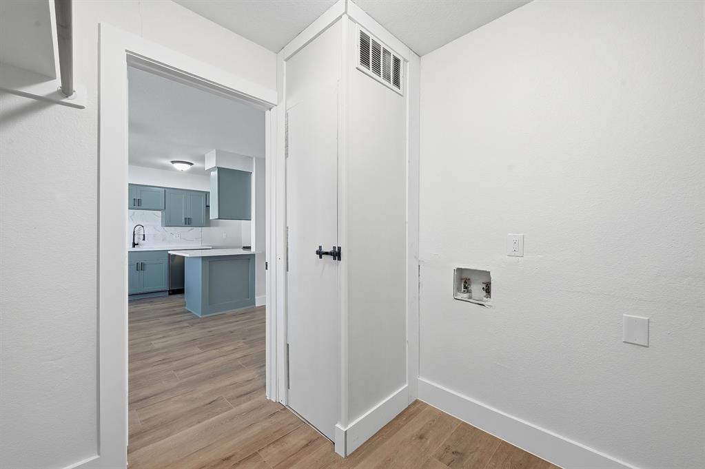 1016 Calcutta Street Hurst, TX 76053 - Photo 26 of 34 a view of a hallway with wooden floor and a bathroom
