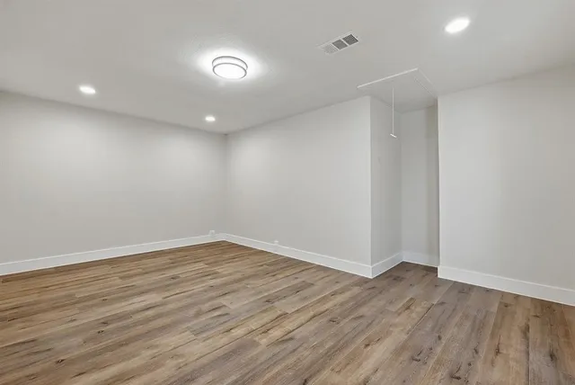 a view of an empty room with wooden floor