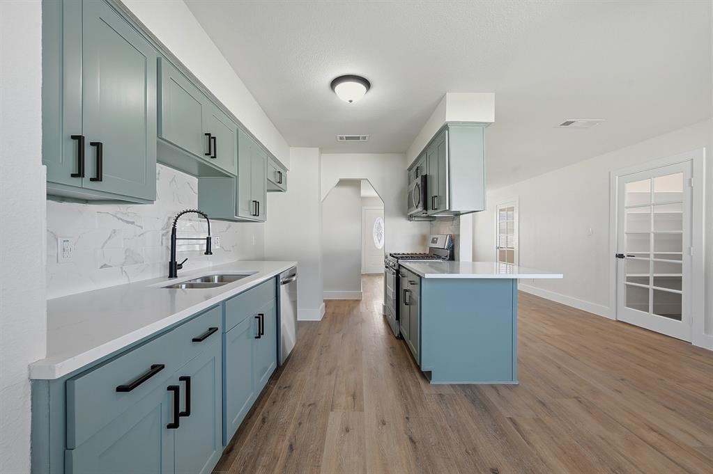 1016 Calcutta Street Hurst, TX 76053 - Photo 6 of 34 a kitchen with stainless steel appliances a sink cabinets and wooden floor