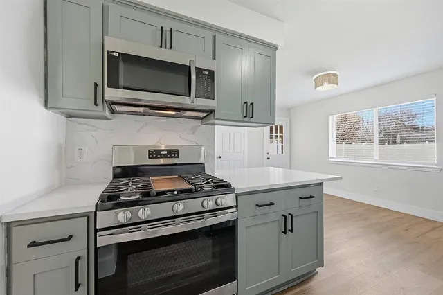 a kitchen with stainless steel appliances white cabinets and stove