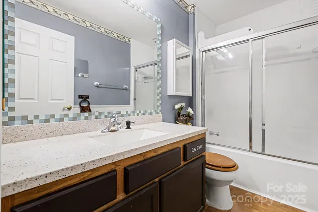 a bathroom with a granite countertop sink toilet and shower