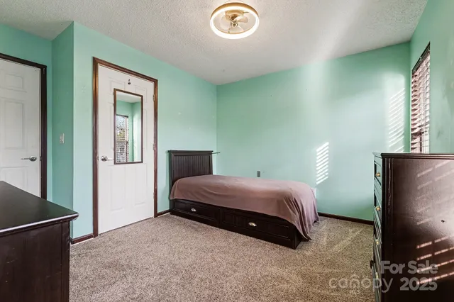 a bedroom with a bed and a flat tv screen on dresser
