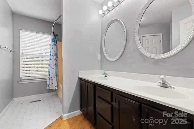 a bathroom with a double vanity sink and a mirror