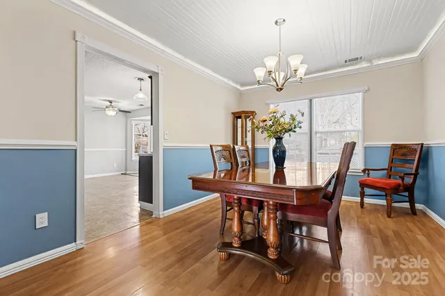 a view of a dining room with furniture a chandelier and wooden floor