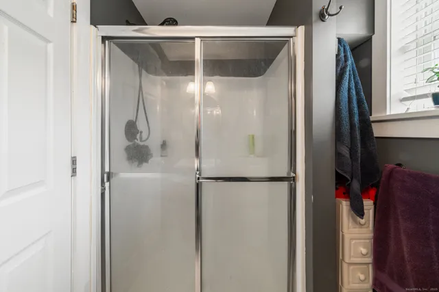 a bathroom with a glass shower door and a glass door